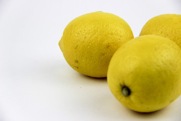 bright, yellow lemons. whole and sliced on a plate.