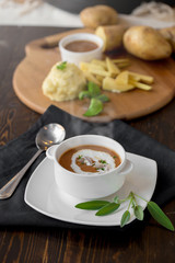 Vegetable cream soup with shrimps and croutons in white bowl close up