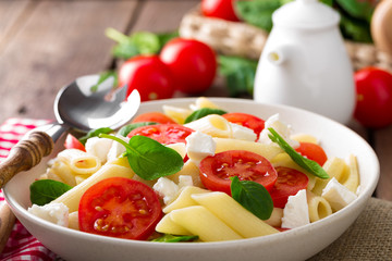 Pasta salad with fresh red cherry tomato and feta cheese. Italian cuisine