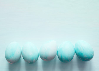 Easter turquoise eggs on light background, top view, copy space, toned