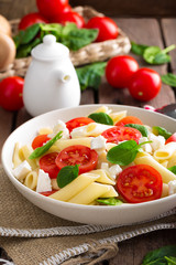 Pasta salad with fresh red cherry tomato and feta cheese. Italian cuisine