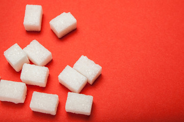 White sugar on a red background, empty space for text.
