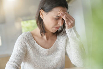 Woman working on laptop having a headache