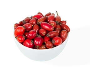 Ceramic bowl full of fresh rose hips isolated on white