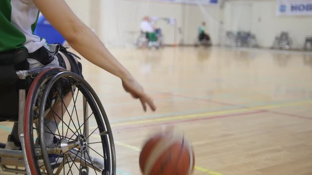 Wheelchair basketball player dribbling the ball quickly during training of disabled sportsmen