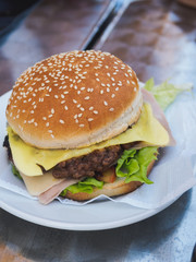 Beef burger on the white plate at table