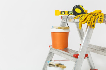 Instruments for renovation apartment room isolated on white background. Wallpaper and accessories for gluing, painting tools. Colorful paint cans. Concept of repair home. Copy space for advertisement.