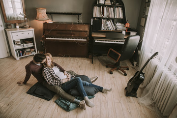 Pregnant woman with a husband sitting on the floor