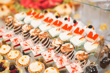 Delicious sweets on wedding candy buffet with desserts, cupcakes