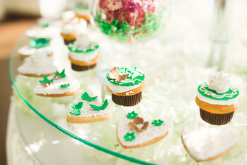 Delicious and tasty dessert table with cupcakes shots at reception closeup