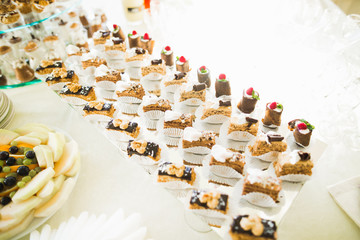 Delicious sweets on wedding candy buffet with desserts, cupcakes