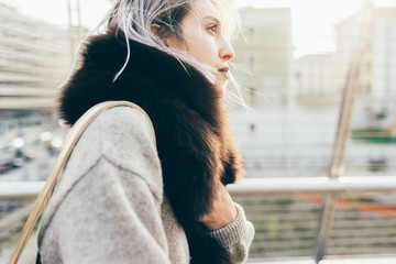 Waist up of young beautiful caucasian purple grey hair woman outdoor in the city looking over, smiling - happiness, carefree, serene concept