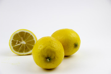 bright, yellow lemons. whole and sliced on a plate.