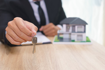 Businessman or sale man giving a house key after sign loan agreement.