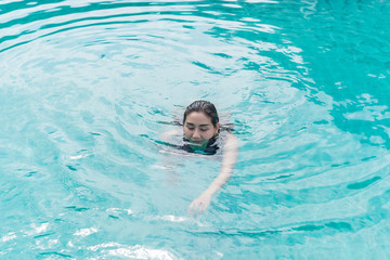 Portrait Asian sexy woman swimming at swimmingpool,thailand people,relax time