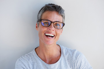 Close up attractive older woman smiling with glasses against white background
