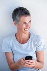 smiling older woman holding mobile phone in hand
