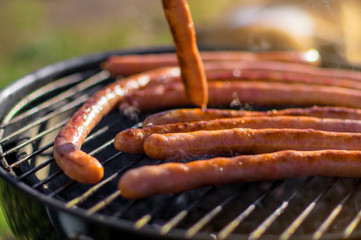 Grilling sausages outside on a barbecue grill