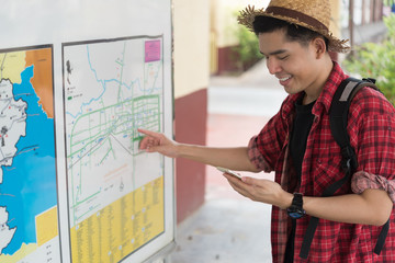 Asian tourist talk telephone for ask location and he looking map at train station,thailand hipster man go to travel