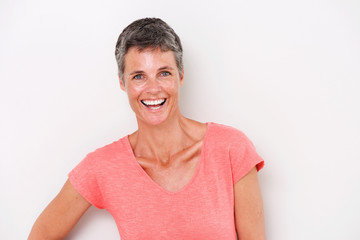Close up attractive middle age woman laughing by white background