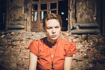 Obraz premium on the background of the destroyed buildings, the girl in the red dress