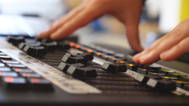 Hands of male sound engineer presses the keys and moves buttons of soundboard . Arms of man working on professional digital audio channel mixer. Amplifier and balance of sound. Close up Slow motion