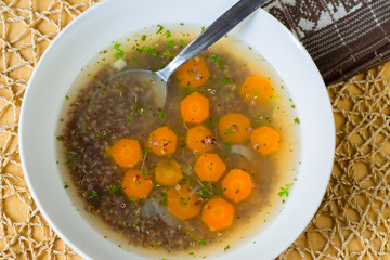 Healthy soup from boiled quinoa and carrot wheel.