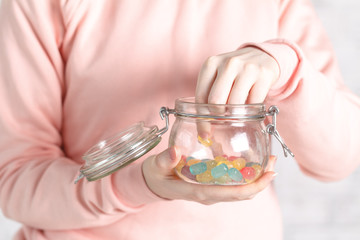 Female holding glass jar full of jelly beans