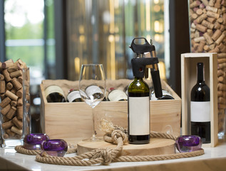 A wine bottle with a corkscrew and an empty glass on a wooden plank, a restaurant interior, in the...