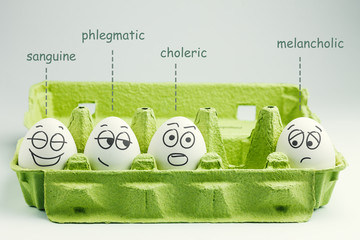 Four eggs in eggbox. Types of temperaments. Sanguine, choleric, phlegmatic and melancholic. - obrazy, fototapety, plakaty