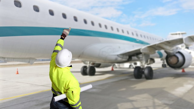 Techniker neben Flugzeug auf Rollfeld