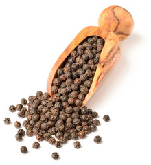 dried black peppercorns in the olive wood scoop, isolated on white