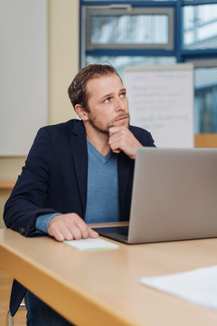 Businessman sitting at a desk deep in thought