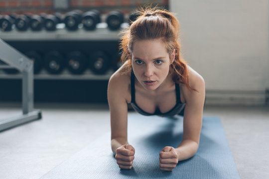 Young woman working out on a mat in a gym