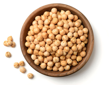 raw chickpea in the wooden plate, isolated on white, top view