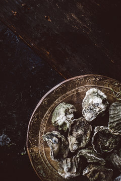 Oysters in shells on old fashioned plate