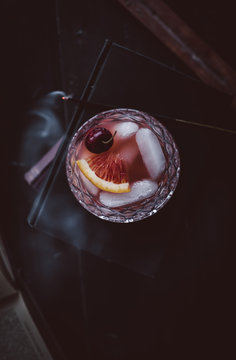 Cocktail with ice cubes, orange slice and cherry