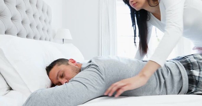 Romantic woman cuddling man on bed 