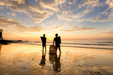 Naklejka premium kids playing at the beach during sunset.