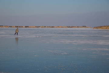 Fototapeta na wymiar Gefrorener Neusiedler See mit Eisschollen und Eisläufern