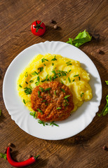 burger with mashed potatoes in white plate on wooden background