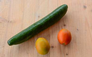 cucumber and tomatoes on wooden background