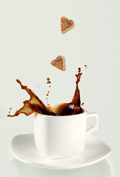 Sugar heart being dropped into coffee creating splash