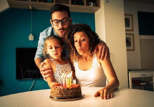 Happy family blowing birthday candles.Celebration concept