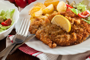 Breaded viennese schnitzel with baked potatoes