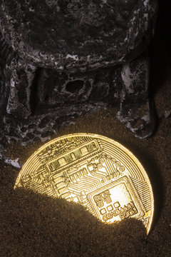 Crypto currency bitkoin at night in the sand near the ancient temple.
