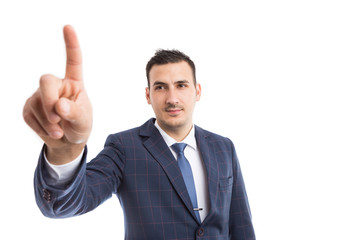 Modern businessman touching invisible screen or display.