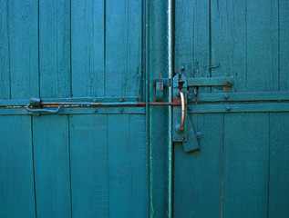 Bright blue color vintage wooden gates with door handle and latch, close up view
