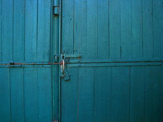 Bright blue color vintage wooden gates with door handle and latch