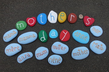 Obraz na płótnie Canvas Happy International Mother's Day with muilticolored stones over black volcanic sand